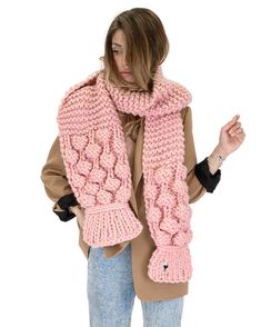 a woman wearing a pink knitted scarf