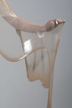 a person's hand reaching for something in the air with liquid pouring out of it