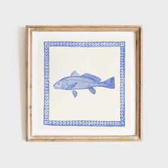 a blue and white fish is hanging on the wall in front of a wooden frame