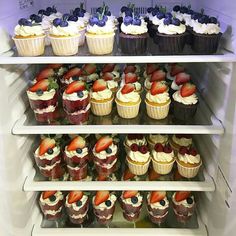 a refrigerator filled with lots of cupcakes and muffins covered in frosting