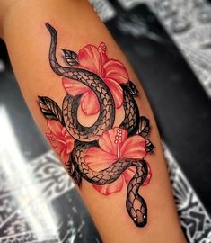 a snake and flower tattoo on the arm