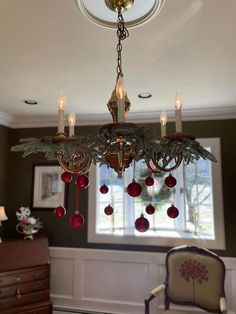 a chandelier hanging from the ceiling in a room with christmas decorations on it