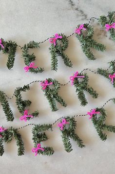 the words happy new year are decorated with pine branches and pink bows on twine