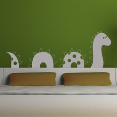 there is a green wall with white dinosaurs on it