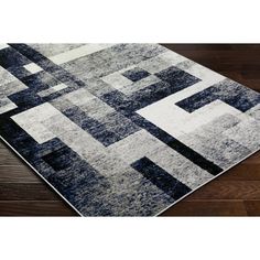 an area rug with squares and rectangles in grey, black and white colors