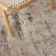 a wooden bench sitting on top of a carpeted floor next to a rug covered in dirt