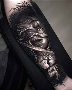 a man's arm with a black and white tattoo design on the forearm,