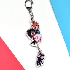 a cartoon character keychain hanging from a metal hook on a colorful background with the word spiderman