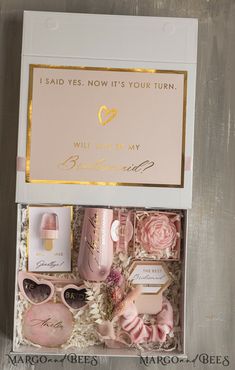 an open box containing pink and gold items, with the words i said yes now it's your turn will you be my bridesmarl?