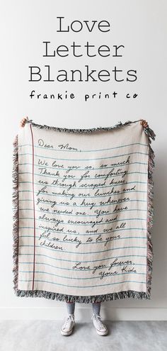 a woman holding up a blanket that says love letter blankets, frankie print co