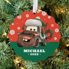 a christmas ornament hanging from a tree with cars and snowflakes on it