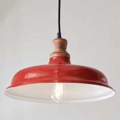 a red and white light hanging from a ceiling fixture with a black cord attached to it