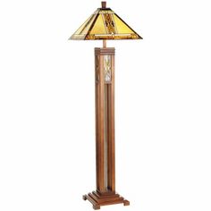 a wooden floor lamp with a stained glass shade on the top and bottom part of it