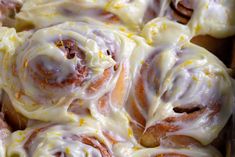 a baking dish filled with cinnamon rolls covered in icing