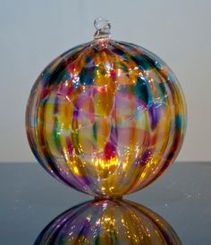 a colorful glass ball sitting on top of a table