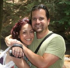 a man and woman taking a selfie in the woods