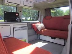 an interior view of a camper van with the kitchen and living room in it