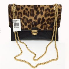 a leopard print purse with a gold chain on the strap and a price tag attached to it