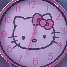 a hello kitty clock with pink hands and numbers on the face is shown in this image