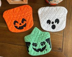 three oven mitts decorated to look like pumpkins and jack - o'- lanterns