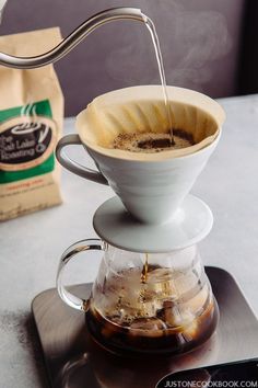 coffee being poured into a cup from a pour - over