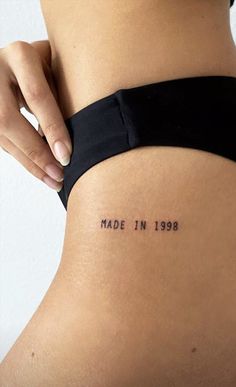 a woman's stomach with the words made in 1989 tattooed on her lower back