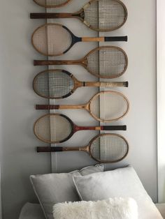 four tennis rackets mounted on the wall above a bed