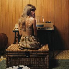 a woman sitting on top of a chair next to a piano