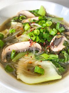 a white bowl filled with soup and vegetables