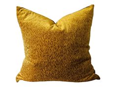 a yellow and brown pillow sitting on top of a white wall