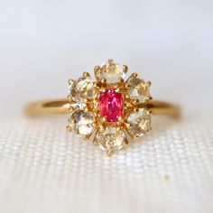 a close up of a gold ring with pink and white stones