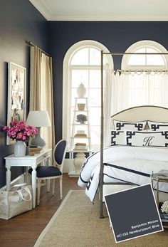 a bedroom with blue walls and white furniture