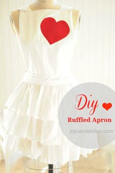 a white dress with a red heart on the back and ruffles around it