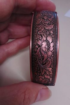 "If you love the densely detailed floral Arts & Crafts patterns of William Morris, this vintage copper bracelet will appeal to you! Well made with a secure closure and wide opening hinge, it is likely from the 70s, and features beautifully undulating flowers and leaves, framed by a milled edge on each side. The glowing floral forms are contrasted effectively by oxidized darker backgrounds, and there are some tarnished areas in keeping with the authentic vintage of this bracelet. The little safet Vintage Engraved Rose Gold Bracelet, Vintage Rose Gold Engraved Bracelet, Handmade Vintage Copper Bracelets, Vintage Copper Bracelet Gift, Vintage Copper Bracelet As Gift, Vintage Copper Bracelet For Gift, Vintage Rose Gold Bracelet, Vintage Copper Bangle Jewelry, Vintage Copper Bangle Cuff Bracelet