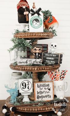 a three tiered christmas tree decorated with halloween decorations and other holiday decorating items