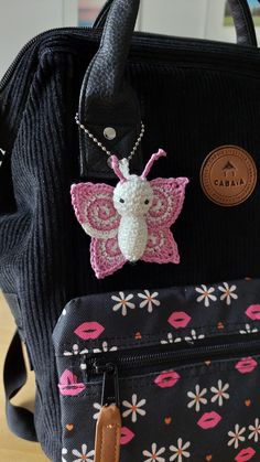 a purse with a crocheted butterfly on the front, and a tag attached to it