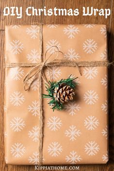 a present wrapped in brown paper with a pine cone on top and the words diy christmas wrap