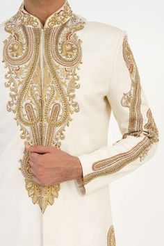 Ivory matka silk sherwani with dabka, beads and french knots hand embroidered motifs. Comes with churidar and a kurta. - Aza Fashions Ceremonial Raw Silk Sherwani With Naqshi, Ceremonial Naqshi Sherwani In Raw Silk, Eid Raw Silk Sherwani With Intricate Embroidery, Eid Sherwani With Intricate Embroidery In Raw Silk, Traditional Raw Silk Sherwani With Intricate Embroidery, Traditional Off White Sherwani With Intricate Embroidery, Ceremonial Cream Nehru Jacket With Zari Work, Raw Silk Sherwani With Intricate Embroidery For Reception, Traditional Off-white Sherwani With Intricate Embroidery