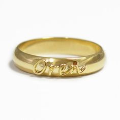 a yellow gold ring with the word love written in cursive writing on it