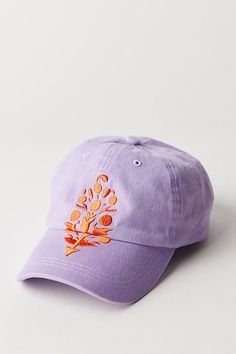 a purple hat with an orange tree embroidered on the front and side, against a white background