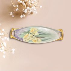 a white and yellow flower on a plate next to some baby's breath flowers