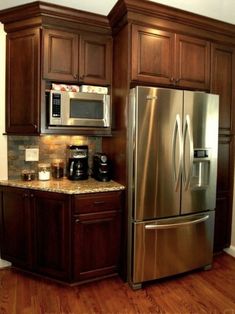 a metallic refrigerator freezer sitting inside of a kitchen