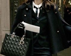 a woman walking down the street carrying a black purse