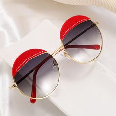 Unleash your inner style guru with these quirky sunglasses. The light golden metal frame, colorful detailing and round shape create an on-trend vintage look.Frame Shape: RoundFrame Color: RedFrame Material: Mixed MaterialsLens Color: GreyLens Material: PCRim Type: Full RimLens Width: 58 mmBridge Width: 17 mmTemple Length: 140 mmFrame Width: 140 mmLens Height: 54 mmWeight: 33 gPolarized: NoSpring Hinge: YesAdjustable Nose Pads: Yes Trendy Round Frame Cat Eye Sunglasses For Summer, Trendy Cat Eye Sunglasses With Round Frame For Summer, Gold Round Frame Sunglasses For Party, Party Sunglasses With Gradient Round Frame, Party Sunglasses With Gradient Round Lenses, Trendy Summer Cat Eye Sunglasses, Gold Round Frame Party Sunglasses, Trendy Metal Round Frame Sunglasses, Trendy Round Sunglasses With Metal Frame