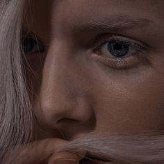 a close up of a person with long hair and a moustache on their face