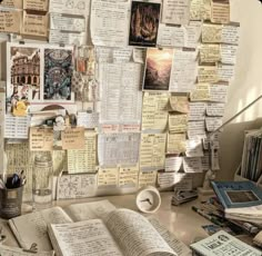 an open book sitting on top of a desk covered in lots of papers and magnets