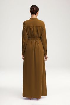 Introducing our luxurious Olivia Button Down Utility Maxi Dress. This utility dress features a button down front and a self fabric tie belt for a sophisticated and exclusive look. Perfect for any occasion, this dress is the epitome of elegance and taste. Model is 5'8 wearing size XS/58". Utility Dress, Jersey Hijab, Silk Maxi, Khaki Dress, Silk Maxi Dress, Pocket Dress, Khaki Green, Tie Belt, Beautiful People