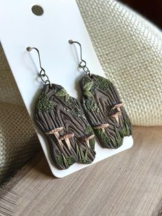 the earrings are made out of wood and have green leaves on them