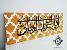 an arabic calligraphy is displayed on a white wall with yellow and white patterning