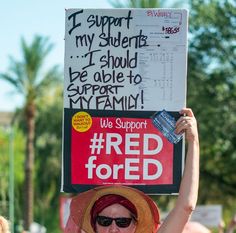 a woman holding up a sign that says we support for redfored and i support my students